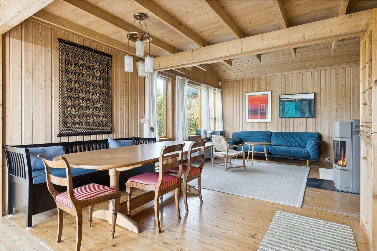 Arkitekttegnet enebolig med tradisjonelt preg og parkering både i garasje og på tomt.