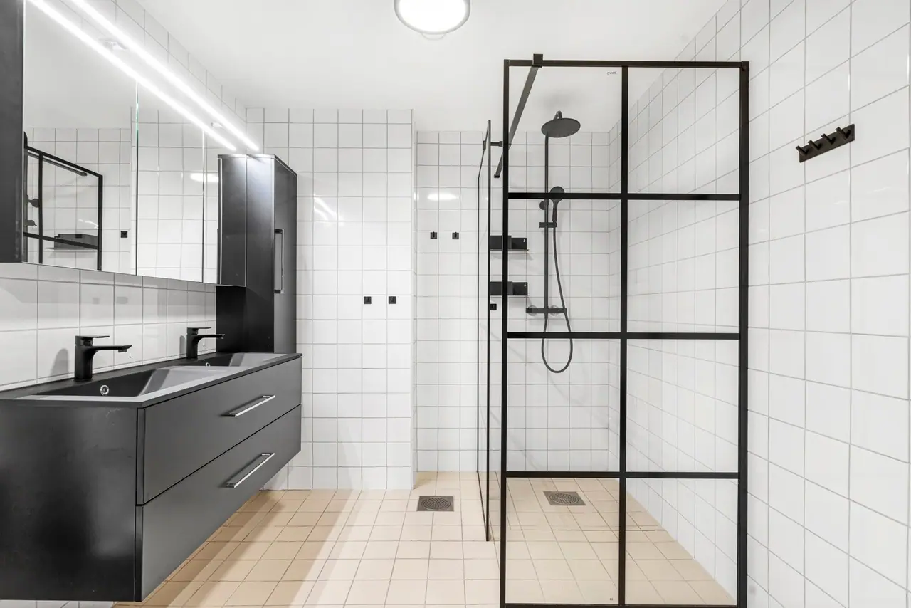 Bathroom in stylish colours with tiled walls and floor. Underfloor heating and a large shower with a waterfall head.