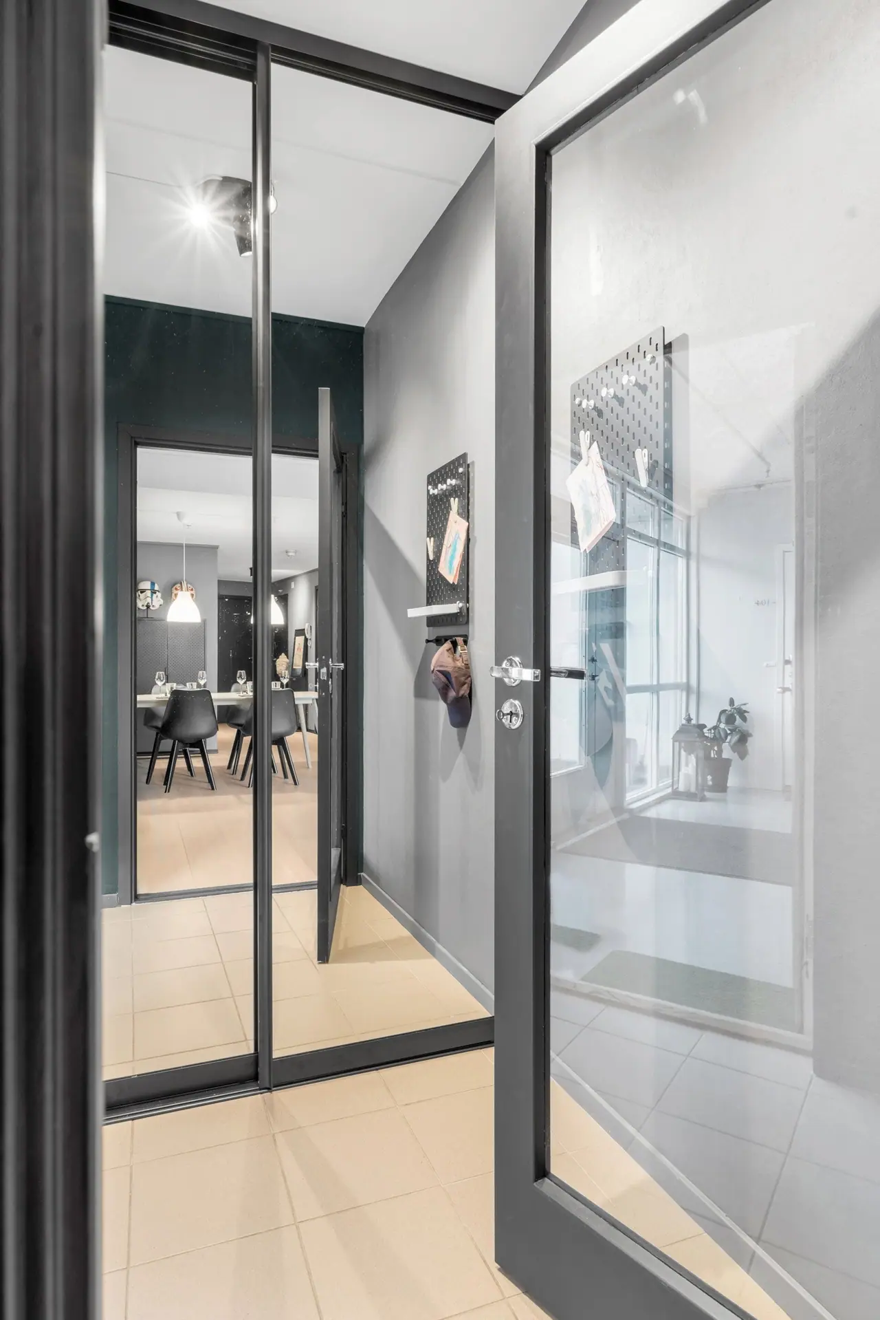 Internal glass door separating the entrance and the living room. In the hallway there is a large wardrobe with mirrored doors.
